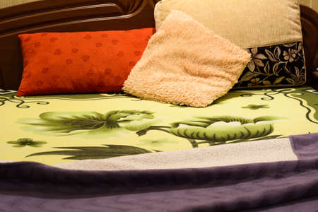Bed with duvet and pillows in the light of the night lampの写真素材