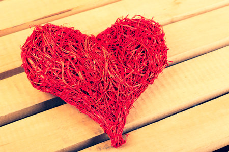 Heart of straw on a light background of woodの写真素材