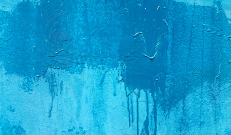 Bright blue painted wall texture with stains and smudgesの写真素材