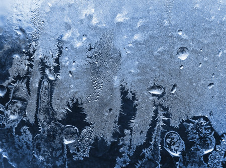 blue frosty natural pattern on winter windowpaneの写真素材