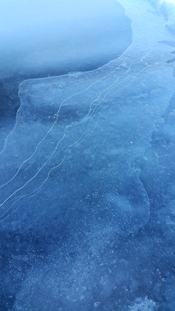 Natural ice texture, winter background, brittle ice on the surface of a frozen riverの写真素材