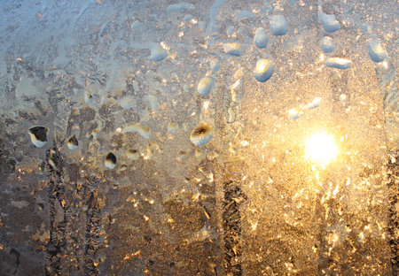 Ice natural pattern and sunlight on winter wundow glassの写真素材