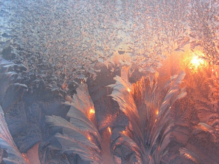 Ice pattern and sunlight on winter window glassの写真素材