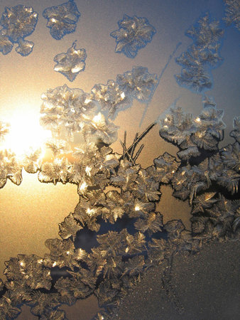 Frosty natural pattern and sunlight on winter windowの写真素材