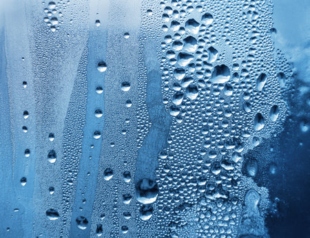 window glass with water drops and frostの写真素材