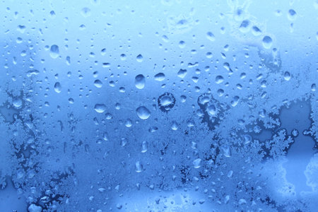blue ice and water drops on winter glassの写真素材