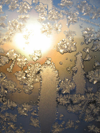 Frosty natural pattern and sunlight on winter windowの写真素材