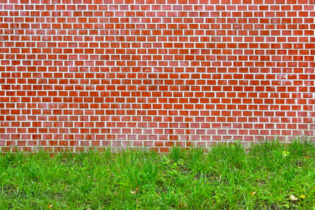 Brick red wall and green grass textureの写真素材