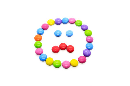 Face with expression of emotions, smiley from multicolored chocolate glazed candies isolated on...
