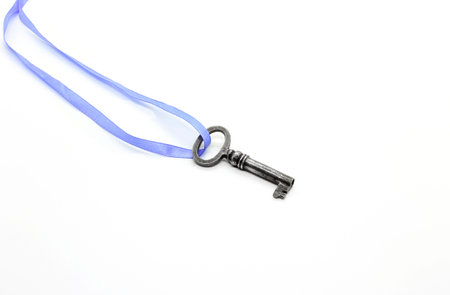 Vintage silver key on blue ribbon isolated on white backgroundの写真素材