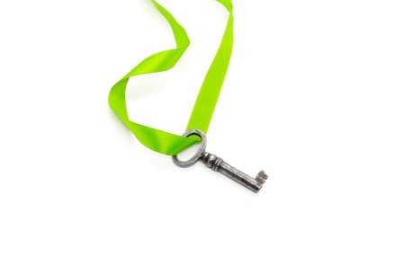Vintage silver key with green ribbon isolated on white backgroundの写真素材