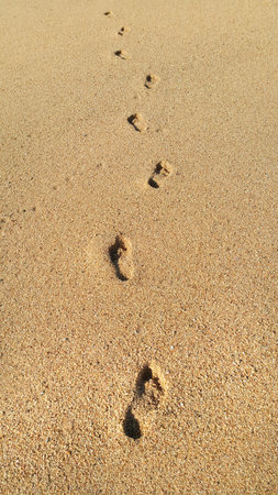 Human footprints in the sand, natural background