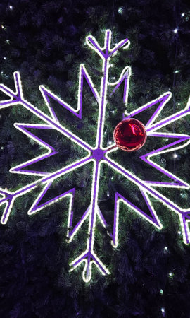 Big glowing snowflake and red glass ball close-up on Christmas tree, Bright and beautiful New Year and Christmas decorationsの写真素材