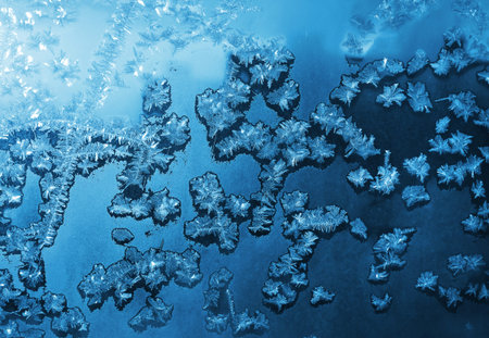 Beautiful ice patterns and sunlight on window glass, natural winter texture
