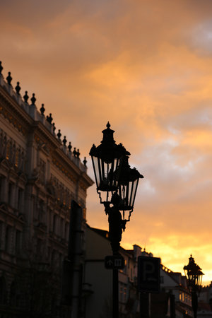 Traditional vintage street lamp and architecture of Prague in the eveningの写真素材