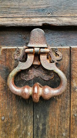 Vintage doorknocker close-up on weathered wooden door background, Troyes, Franceの写真素材