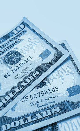 Banknotes of ten american dollars, close-up, blue toned imageの写真素材