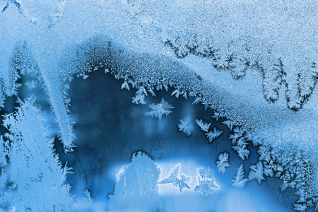 Winter window glass with beautiful ice patterns, closeup natural texture