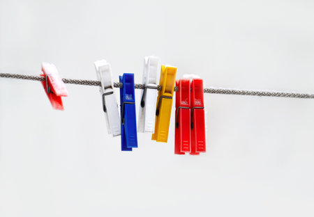 Colorful plastic clothespins hanging on a ropeの写真素材