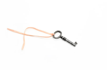 Vintage silver key with pink ribbon isolated on white background