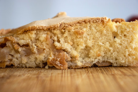 Piece of traditional thanksgiving apple cinnamon pie, apples and walnuts on the wooden cutting board...