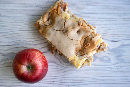 Piece of traditional thanksgiving apple cinnamon pie, apples on the wooden cutting board on the...