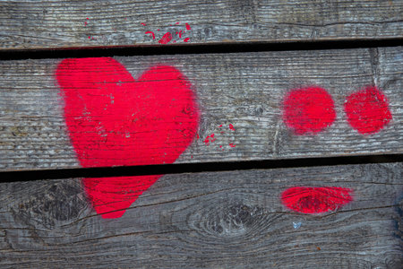 Love heart spray painted on wooden wall background. One red heart on wood boards fence backdrop. Happy Valentines day. 14th February Wallpaper, design concept. Copy space. Backdrop Post card. Close upの写真素材