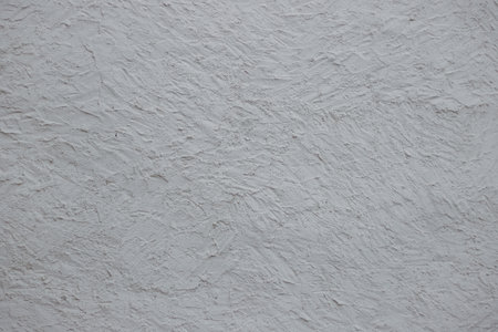 Wall fragment with scratches and cracks. Concrete cement wall texture with three dimensional elements. Modern design. Retro grunge style. Copy space.の写真素材