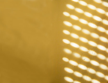 Blurred lights and shadows from the blinds on the concrete wall on a sunny day, interior design. Abstract background, banner, pattern, texture. Yellow, gray, white colors. Copy space.の写真素材
