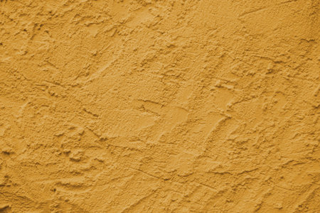 Yellow wall with scratches and cracks. Concrete cement wall texture with three dimensional elements. Modern design. Retro grunge style. Copy space.の写真素材