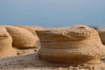 Natural sand sculptures made by wind on the Baltic sea beach. Gulf of Riga in Latvia Landscape. Blue sky and sea on the background. Copy space. Selective focus.の写真素材