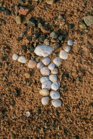 A little man figure made of sand and shells on the sea beach. Latvia, Baltic, Gulf of Riga. Copy...