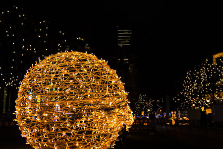 Closeup of intertwined golden string lights. Abstract view of crisscrossing glowing yellow LED garland with small bright bulbs, radiating light against a dark background. Berlin, Germany. Copy spaceの写真素材