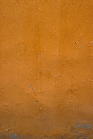 Closeup of an orange wall showcasing its texture and natural imperfections, perfect for background and design projects, Vertical mage shows urban decay with its rustic and vibrant elementsの写真素材