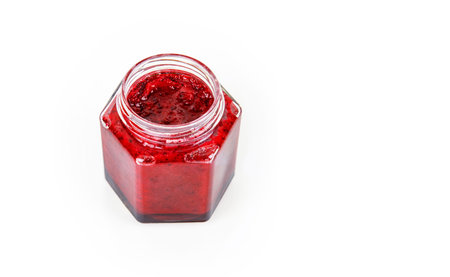 Top view of fresh, vibrant red currant berry jam in an open glass jar, perfect for breakfast spreads...