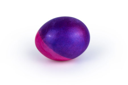 Vibrant single easter egg with   unique blend of purple and pink hues, isolated on white background. Color contrast, creativity, holiday decoration, symbolism of rebirth. Copy space. Selective focusの写真素材