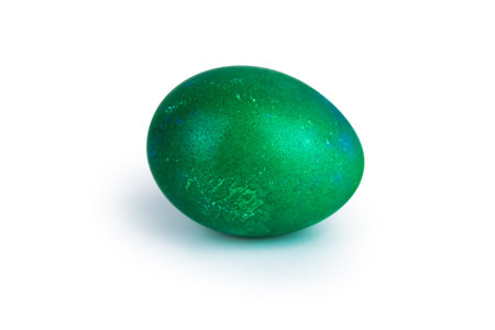 Single emerald green easter egg with  glowing shell pattern, isolated on white background. Color contrast, creativity, holiday decoration, symbolism of rebirth. Copy space. Selective focusの写真素材