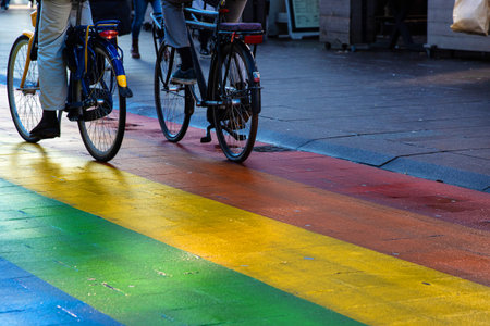 Cyclists riding a bicycles on a Regenboogvlag in the Grote Marktstraat. Rainbow street with bikers...