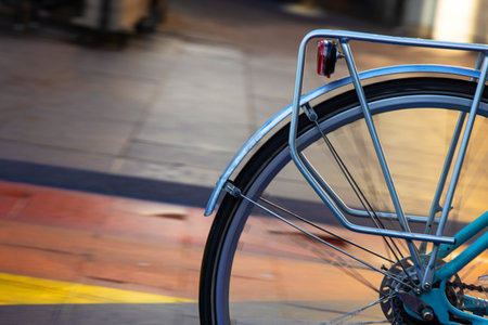 Closeup of a bicycle rear wheel, riding on a city street with colorful pavement, symbolizing sustainable mobility, and cycling lifestyle in the city.  Copy space. Selective focus. Movement effect.の写真素材