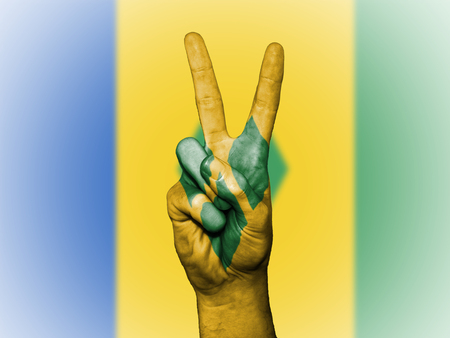 Hand showing the international symbol for peace, decorated in the national colors of Saint Vincent and the Grenadinesの写真素材