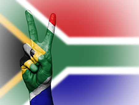 Hand showing the international symbol for peace, decorated in the national colors of South Africaの写真素材