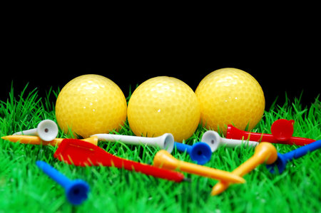 golfball in green fairway, isolated on black background の写真素材