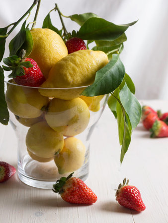 Lemons and strawberries in a glass bowlの写真素材