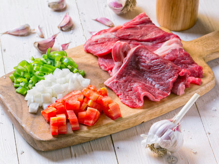 Raw meat on wodden board with vegetablesの写真素材