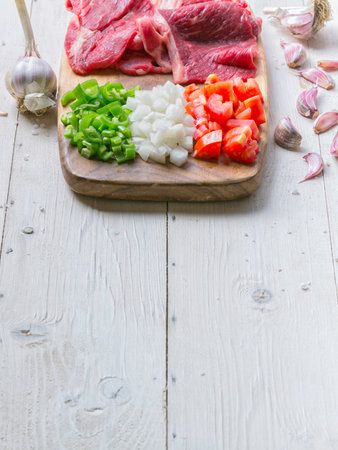 Raw meat on wodden board with vegetablesの写真素材