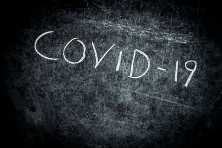 Coronavirus, Covid-19 drawn text with chalk on blackboardの写真素材