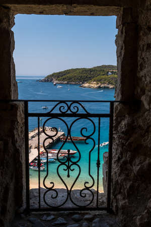 View through a balcony of the Badiali Castle on the island of San Nicola, Tremiti Islands and ours the splendid blue seaの写真素材
