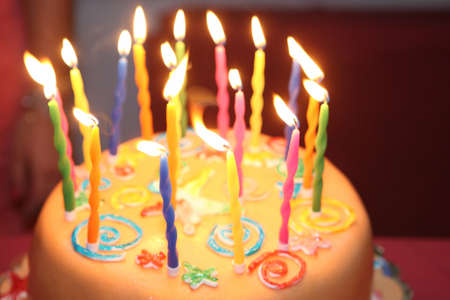 Tasty birthday cake with eighteen burning candles on table.の写真素材