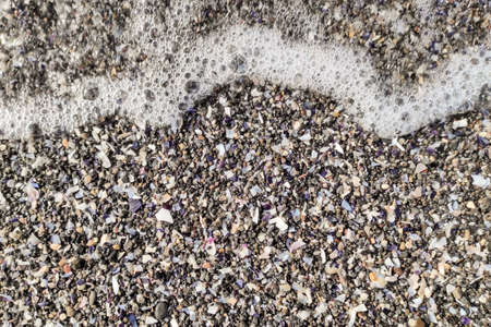 Soft wave on the black volcanic sandy beach. Background with copy space.の写真素材