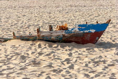 Small fishing boat broken by a storm and abandoned on a beach of Sal Island in Cape Verde, Africa